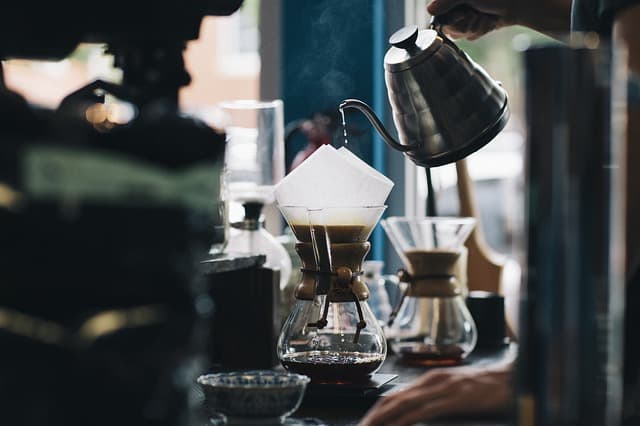 Someone pouring water over coffee