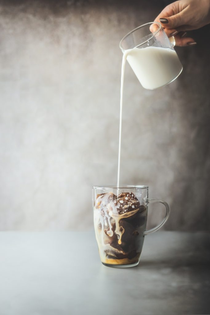 Ice coffee cubes in a glass with milk